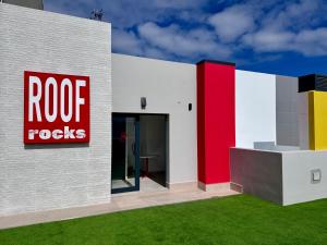 un edificio con un letrero de rocas de gallo en él en Sholeo Lodges Las Palmas Flats, en Las Palmas de Gran Canaria