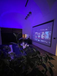 un soggiorno con illuminazione viola e TV di SPAYA JACUZZI centrum apartment - with home cinema & private parking a Košice