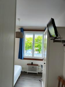 Cette chambre dispose d'une télévision, d'une fenêtre et d'un lit. dans l'établissement Le Parc aux Huîtres, à Cayeux-sur-Mer