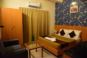 - une chambre avec un lit, un canapé et une chaise dans l'établissement Rajalakshmi Comforts mysuru, à Mysore