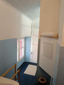 bagno con pavimento piastrellato blu e finestra. di Studette pour 1 ou 2 personnes a Chaumont