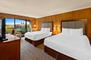 a hotel room with two beds and a flat screen tv at Best Western PLUS Inner Harbour Hotel in Victoria