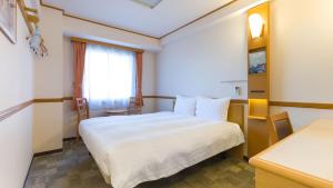 a hotel room with a white bed and a window at Toyoko Inn Wako-shi Ekimae in Wako