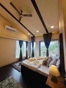 una camera da letto con un grande letto con tende blu di Lifeline Villas - Skyy High Luxurious Villa With Table Land & Valley View Villa a Panchgani