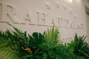 a sign that reads kahalaaza with plants at Rahat Palace Hotel in Almaty