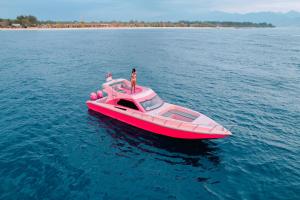 een man op een roze boot in het water bij PinkCoco Gili Trawangan - Constant Surprises - for Cool Adults Only in Gili Trawangan