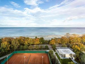 - une vue aérienne sur un court de tennis et l'océan dans l'établissement Novotel Gdańsk Marina, à Gdańsk