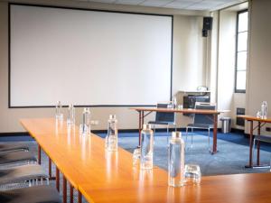 uma sala de conferências com uma mesa longa com óculos em Hôtel Mercure Rochefort La Corderie Royale em Rochefort