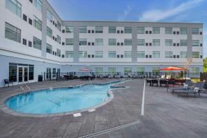 un gran edificio con piscina frente a un edificio en Cambria Hotel Nashville Airport en Nashville