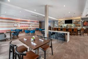 un restaurante con mesas y sillas y un bar en Cambria Hotel Nashville Airport en Nashville