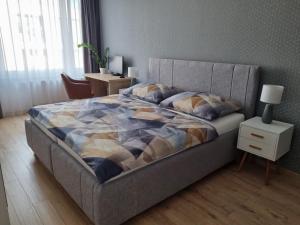 1 dormitorio con 1 cama y mesita de noche con lámpara en Apartment Paulínska, en Trnava