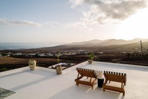 uma varanda com 2 cadeiras e vista para o oceano em César Lanzarote Luxury Boutique Hotel - Adults Only em La Asomada