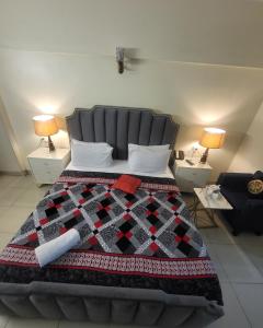 a bedroom with a bed with a quilt on it at Hotel Rooms DHA in Karachi