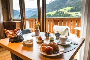 einen Tisch mit Essen drauf mit Bergblick in der Unterkunft Sule Hof Agriturismo in St. Ulrich in Gröden