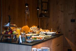 ein Buffet mit vielen verschiedenen Speisen auf der Theke in der Unterkunft Sule Hof Agriturismo in St. Ulrich in Gröden