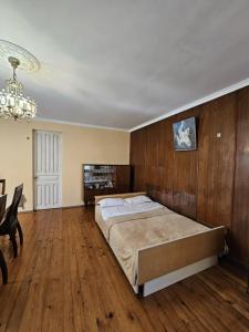 1 dormitorio con 1 cama grande y paredes de madera en Cozy cottage, en Zugdidi