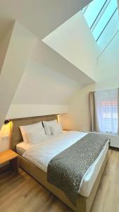 a bedroom with a large bed with a window at Hotel Karlova Prague in Prague