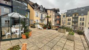 a patio with a table and chairs and buildings at Lakeside-Apartment-2 Appartement avec une grande terrasse et vue panoramique sur le lac in Vevey