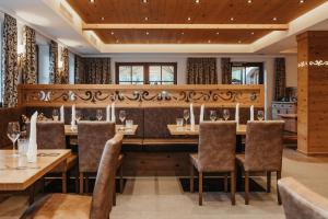 un restaurant avec une grande table et des chaises dans l'établissement Hotel Lammwirt, à Grossarl