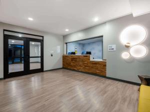 una stanza vuota con una hall con pavimenti e luci in legno di ECHO Suites Extended Stay by Wyndham Indianapolis AmeriPlex a Indianapolis