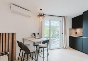 een keuken en eetkamer met een tafel en stoelen bij Appart Hotel Neostelia in Annecy