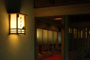 een licht aan de zijkant van een gebouw met een deur bij Tsukihitei in Nara