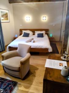 a bedroom with a large bed and a chair at Maison Rebleuthof Sauna & Fitness in Riquewihr