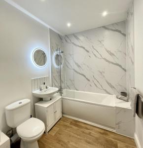 uma casa de banho com um WC, um lavatório e uma banheira em New apartment in town centre em Bournemouth