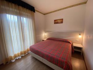 una piccola camera con letto e finestra di Hotel International a Tarvisio