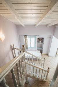 eine Treppe in einem Haus mit weißen Wänden und Holzdecken in der Unterkunft PARALIA Stoudios in Parga