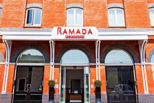 ein rotes Backsteingebäude mit einem Rambala-Schild drauf in der Unterkunft Ramada by Wyndham Belfast in Belfast