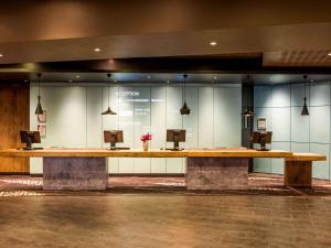 a large wooden table in a room with mirrors at ibis Paris Montmartre Sacré-Coeur in Paris