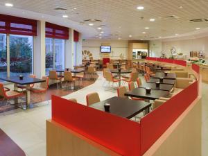 a restaurant with tables and chairs in a cafeteria at ibis Paris Montmartre Sacré-Coeur in Paris