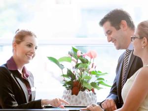 um grupo de pessoas sentadas em torno de uma mesa com uma planta em Novotel Zürich Airport Messe em Glattbrugg