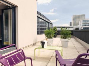 uma varanda com cadeiras e uma mesa num edifício em Mercure Paris Bercy Bibliothèque em Paris