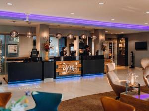 a bar in a restaurant with two people at a counter at Mercure Hotel Hamburg City in Hamburg