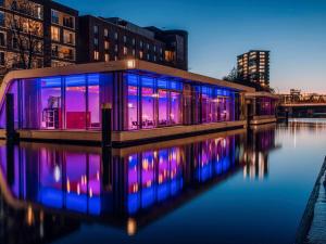 a building with blue and purple lights on the water at Mercure Hotel Hamburg City in Hamburg