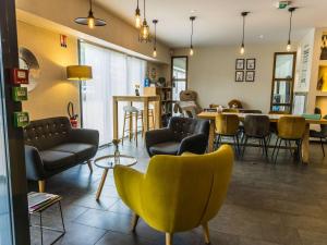 ein Wohnzimmer mit Sofas, Tischen und Stühlen in der Unterkunft Novotel Suites Rouen Normandie in Rouen