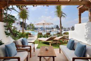 une terrasse avec des chaises et des tables, ainsi qu'une piscine. dans l'établissement Park Hyatt Dubai, à Dubaï