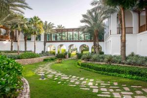 une cour avec des palmiers et un bâtiment dans l'établissement Park Hyatt Dubai, à Dubaï