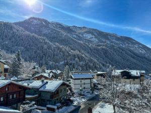 een stad bedekt met sneeuw met een berg op de achtergrond bij Apartments Les Crouses in Valtournenche