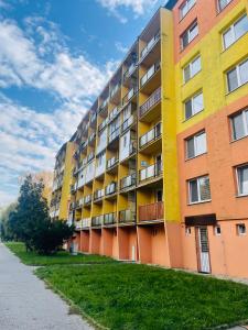 un immeuble d'appartements jaune et orange dans l'établissement Fewdays Michalovce, à Michalovce