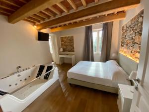 een slaapkamer met een groot bed en een bad bij Il Tiglio Jacuzzi&Sauna in Lucca