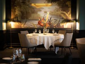 uma mesa num restaurante com um vaso de flores em Hôtel Mercure Rochefort La Corderie Royale em Rochefort