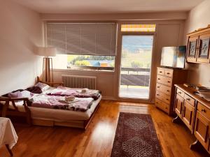 een slaapkamer met een bed, een dressoir en een raam bij GAMSBLICK Bad Aussee Ferienwohnung in Bad Aussee