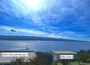 - une vue sur une grande étendue d'eau avec un bâtiment dans l'établissement Bella vista with jacuzzi 1, à Omiš