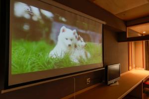 dos perros blancos en una pantalla de TV en una habitación en Yumenoi, en Himeji