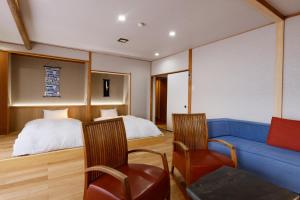 1 dormitorio con sofá azul y cama en Yumenoi, en Himeji