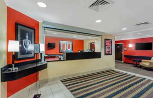 a lobby with orange walls and a waiting room at Extended Stay America Select Suites - Chicago - O'Hare in Rosemont