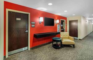 a lobby with a waiting room with a chair and a television at Extended Stay America Select Suites - Chicago - O'Hare in Rosemont